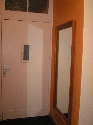 Blick auf die Wohnungstür und den Spiegel im Eingangsbereich.