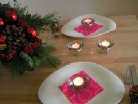 Dekorierter Tisch mit 2 Tellern, Besteck und Kerzen